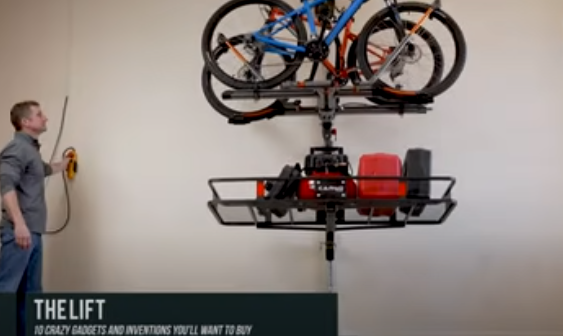 Person using motorized lift to organize heavy objects in a garage.